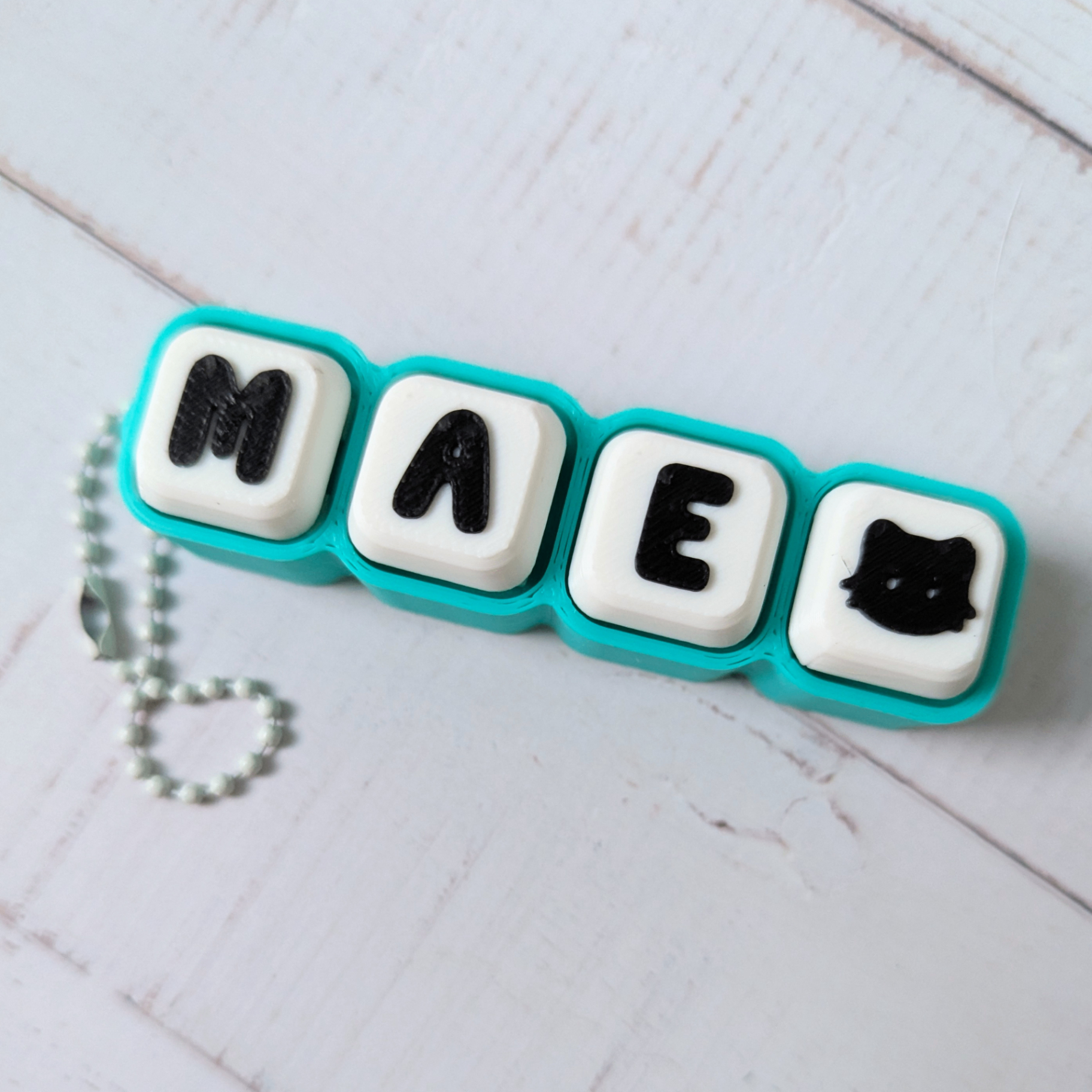 Handmade turquoise Clicker with MAE and a cat icon on a ball chain